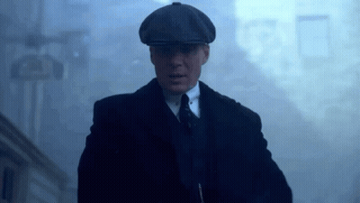 Man In Suit And Hat Walking Through Foggy Street GIF