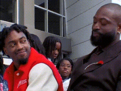 Man In Suit And Man In Red Jacket With Crowd GIF