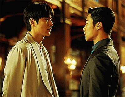 Man In Suit And Man In White Jacket Look At Each Other GIF