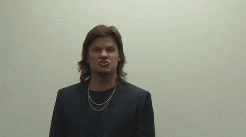 Man In Suit And Necklace Making Angry Face GIF