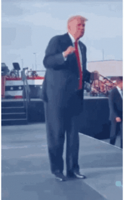 Man In Suit And Red Tie On Stage GIF