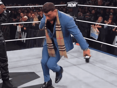 Man In Suit And Scarf In AEW Ring GIF