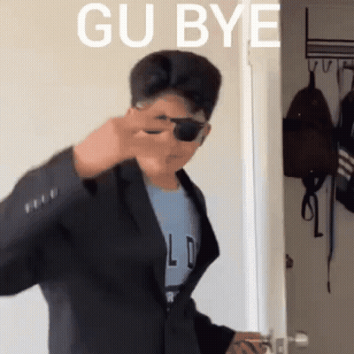 Man In Suit And Sunglasses In Front Of Gu Bye Door GIF