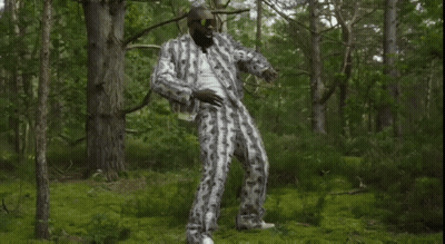 Man In Suit And Sunglasses Standing In Forest GIF