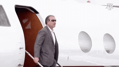 Man In Suit And Sunglasses Walking Out Of Airplane GIF