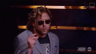 Man In Suit And Sunglasses With AEW Logo GIF