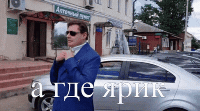 Man In Suit And Sunglasses With Sign Аптечный Пункт GIF
