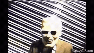 Man In Suit And Tie Against Colorful Geometric Pattern GIF