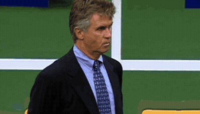 Man In Suit And Tie Against Green Wall GIF