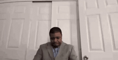 Man In Suit And Tie At Closet Door GIF