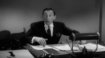 Man In Suit And Tie At Desk With Papers GIF
