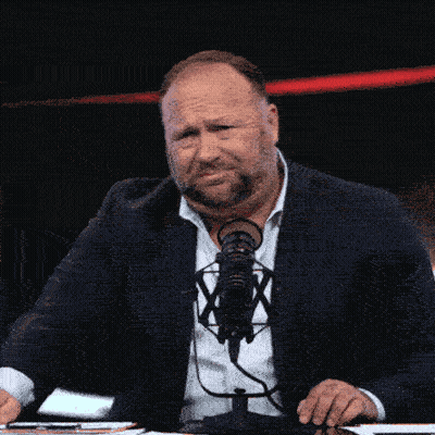Man In Suit And Tie At Microphone With X GIF