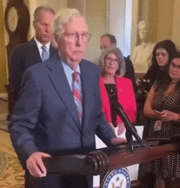 Man In Suit And Tie At Podium With US Seal GIF