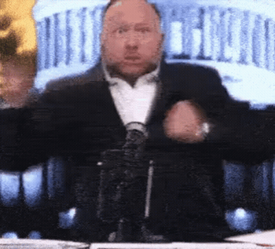 Man In Suit And Tie At Table With Microphone GIF