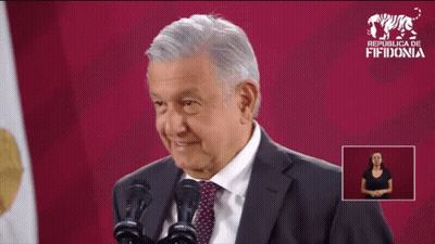 Man In Suit And Tie At Two Microphones With Sign Republica Fifidonia GIF