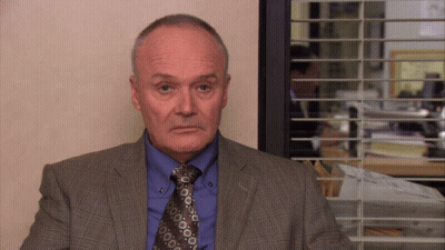 Man In Suit And Tie At Window With Blinds GIF