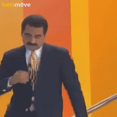Man In Suit And Tie At Yellow Wall With Betsmove Logo GIF