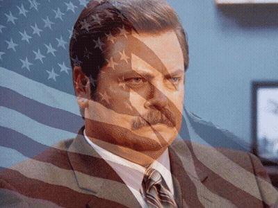 Man In Suit And Tie Behind American Flag GIF