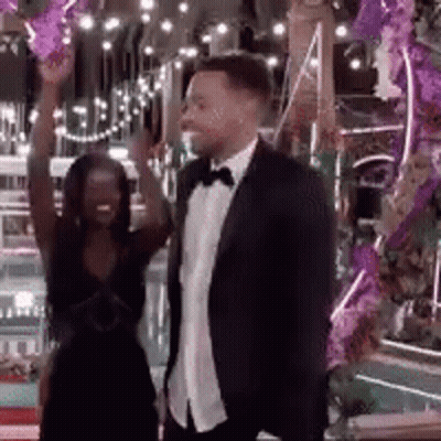 Man In Suit And Tie Beside Woman In Dress GIF