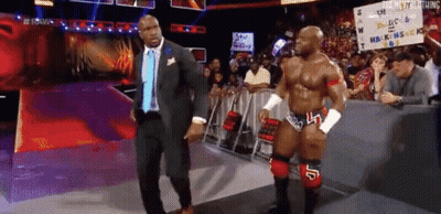 Man In Suit And Tie Beside Wrestler GIF