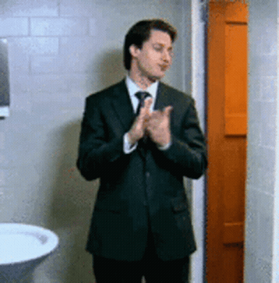 Man In Suit And Tie Clapping In Bathroom GIF