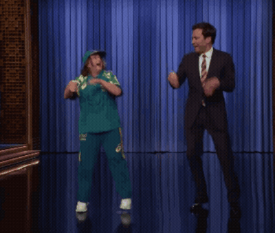 Man In Suit And Tie Dancing With Girl In Green GIF