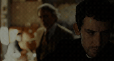 Man In Suit And Tie Eyes Closed In Dark Room GIF
