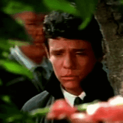 Man In Suit And Tie Eyes Closed In Front Of Tree GIF