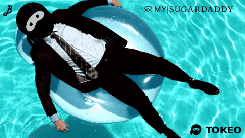 Man In Suit And Tie Floating In Swimming Pool GIF