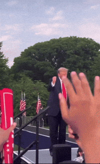 Man In Suit And Tie Giving Thumbs Up On Stage GIF