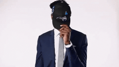 Man In Suit And Tie Hiding Face Behind Hat GIF