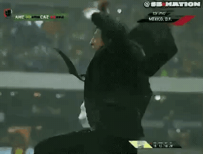 Man In Suit And Tie Holding Head On Soccer Field GIF