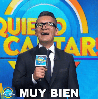Man In Suit And Tie Holding Microphone Beside Muy Bien Sign GIF