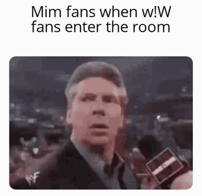 Man In Suit And Tie Holding Microphone To Crowd GIF