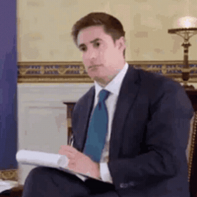 Man In Suit And Tie Holding Paper And Pen GIF