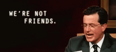 Man in Suit and Tie Holding Paper Saying We're Not Friends