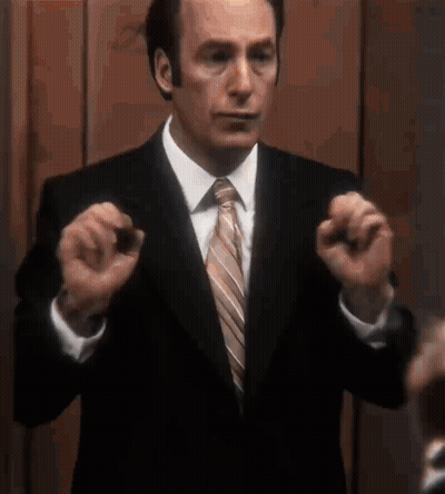 Man In Suit And Tie Holding Something GIF