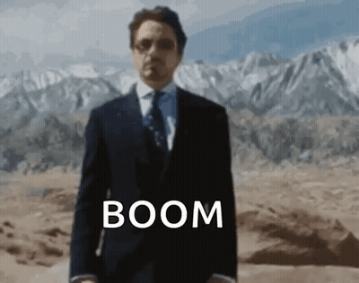 Man In Suit And Tie In Desert With Word Boom GIF