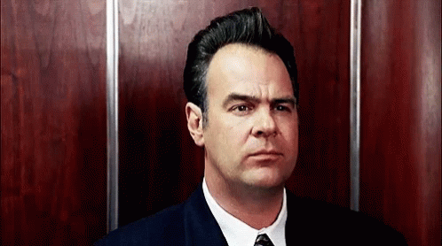 Man In Suit And Tie In Elevator Looking At Camera GIF