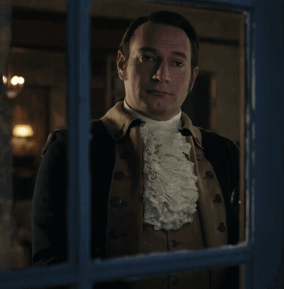 Man In Suit And Tie In Front Of Bookshelf Saying Order GIF