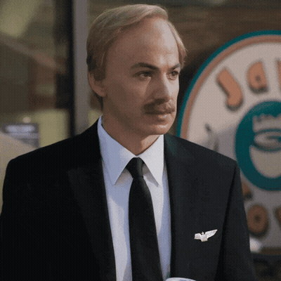Man In Suit And Tie In Front Of Coffee Shop GIF