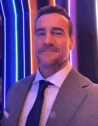 Man In Suit And Tie In Front Of Colorful Background GIF