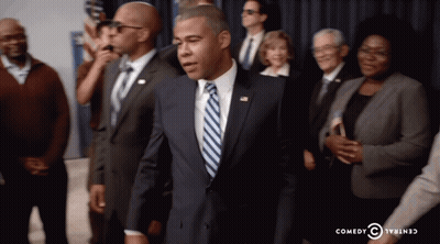 Man In Suit And Tie In Front Of Crowd Comedy Central Logo GIF