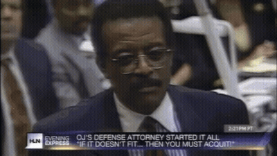 Man In Suit And Tie In Front Of Evening Express Screen GIF