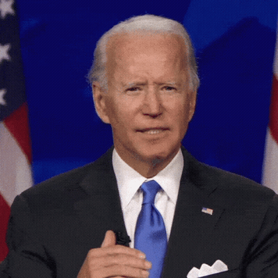 Man In Suit And Tie In Front Of Flag GIF