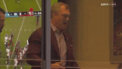 Man In Suit And Tie In Front Of Football Field GIF