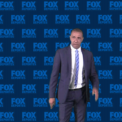 Man in Suit and Tie in Front of Fox Deportes Background