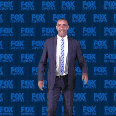 Man In Suit And Tie In Front Of Fox Deportes Background GIF
