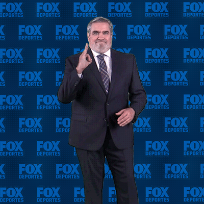 Man In Suit And Tie In Front Of Fox Deportes Background GIF