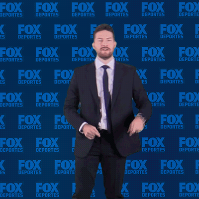 Man in Suit and Tie in Front of Fox Deportes Background